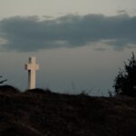 a white cross on a hill, tomb