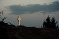 a white cross on a hill, tomb