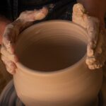 person holding white clay pot